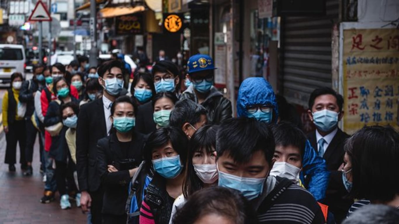 Anwohner warten in Hongkong auf eine Lieferung von chirurgischen Masken, die in einem nahe gelegenen Laden verkauft werden.