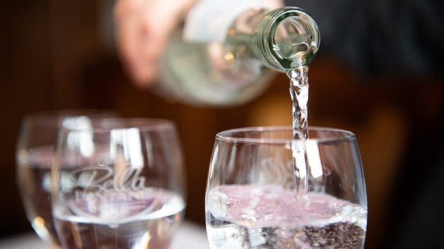 Der Wassersommelier Martin Metzinger schenkt Mineralwasser in ein Glas ein.