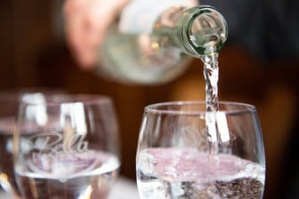 Der Wassersommelier Martin Metzinger schenkt Mineralwasser in ein Glas ein.