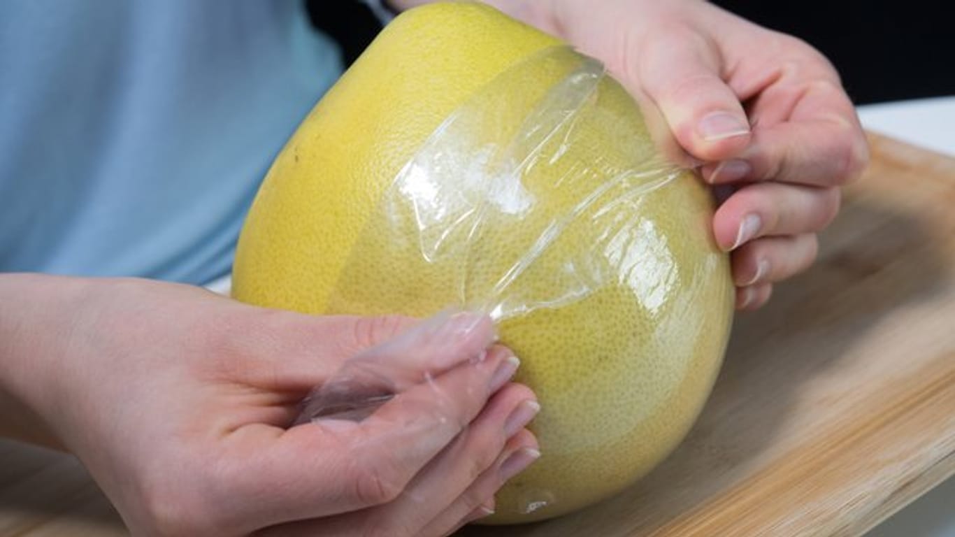 Die Folie um eine Pomelo dient dem Verdunstungsschutz.