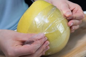 Die Folie um eine Pomelo dient dem Verdunstungsschutz.