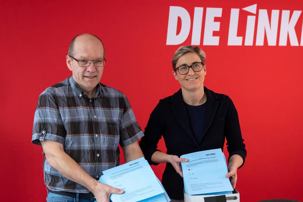 Die Fraktionsvorsitzende der Linken im Thüringer Landtag, Susanne Hennig-Wellsow und Abstimmungsleiter Holger Hänsgen, zeigen die Stimmzettel: Knapp 95 Prozent votierten für die Annahme des Koalitionsvertrages.