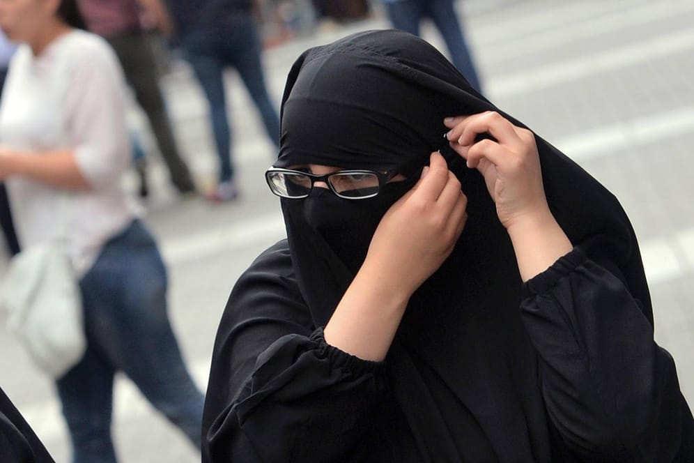 Eine junge Muslima richtet bei einer Kundgebung radikaler Muslime in Offenbach ihren Gesichtsschleier. (Archivbild)