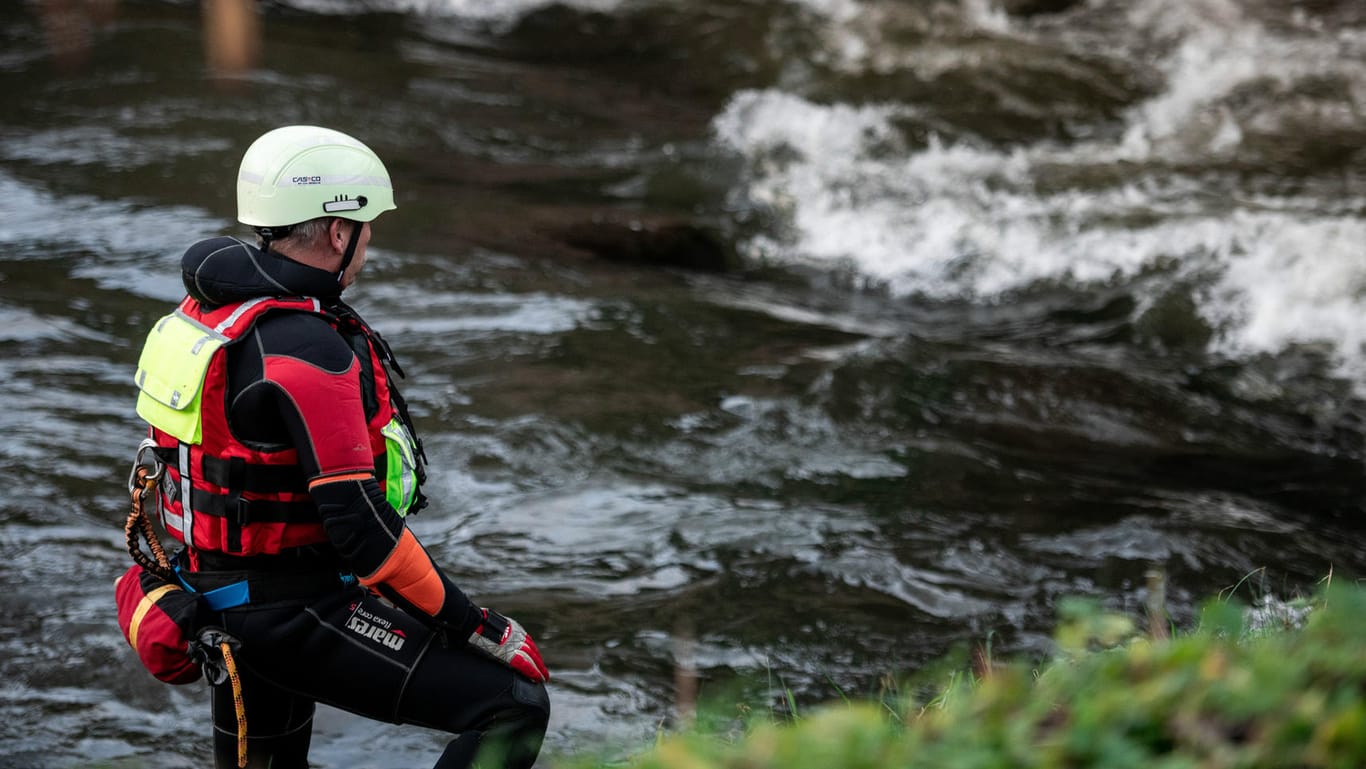 Ein Feuerwehrmann steht am Ufer des Flusses Hönne: Es wird befürchtet, das Kind könnte in das Gewässer gestürzt sein.