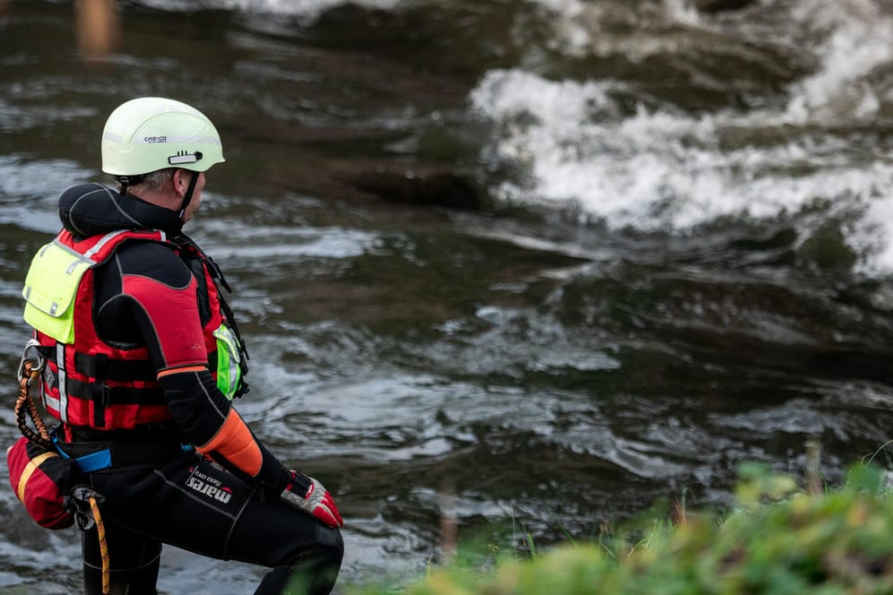 Ein Feuerwehrmann steht am Ufer des Flusses Hönne: Es wird befürchtet, das Kind könnte in das Gewässer gestürzt sein.