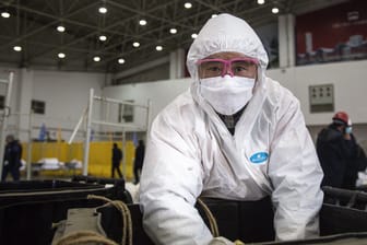 Stadt Wuhan in China: Ein Arbeiter trägt eine Maske, während er an einer Reinigungsanlage arbeitet.