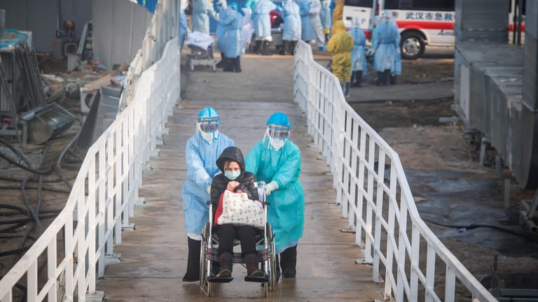 Mediziner bringen einen mit dem Coronavirus infizierten Patienten auf die Isolierstation in einem der eilig errichteten Krankenhäuser in Wuhan.