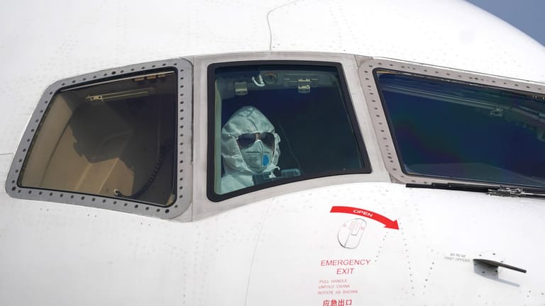 Pilot mit Schutzanzug im Cockpit: Auf dem Flughafen von Wuhan.