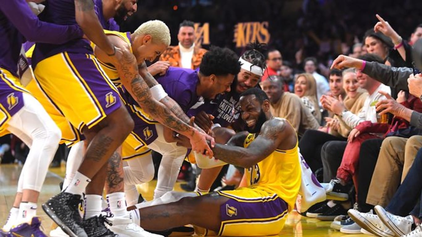 LeBron James (sitzend) wird nach mehreren erfolgreichen Drei-Punkte-Würfen für die Lakers von seinen Mitspielern bejubelt.