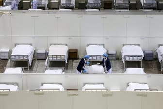 Medizinisches Personal bereitet Betten in einem provisorischen Krankenhaus vor.