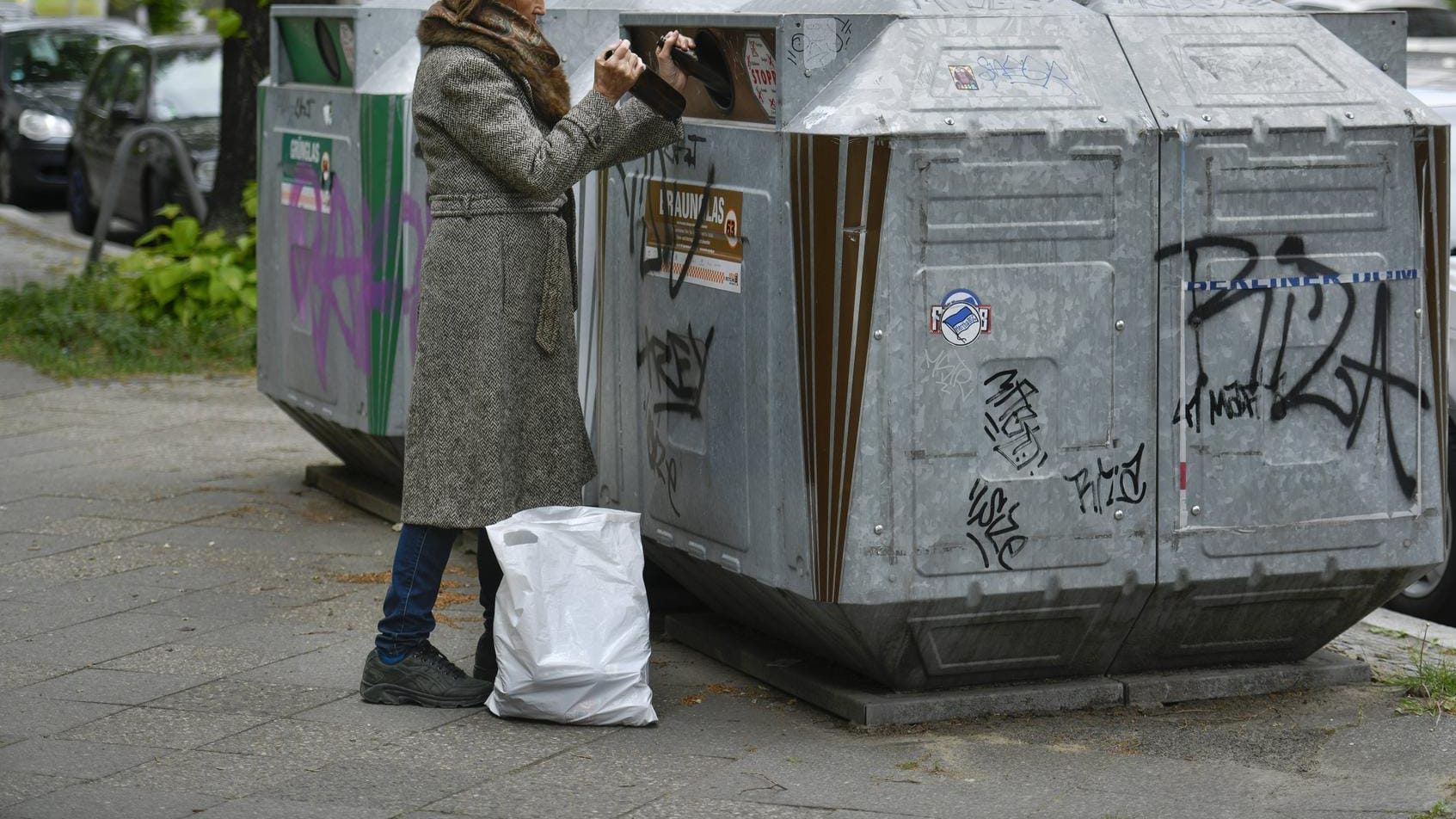 Eine Frau entsorgt Altglas in einem Container: In Essen ist eine Frau bei der Glasentsorgung überfallen worden. Eine Frau entsorgt Altglas in einem Container: In Essen ist eine Frau bei der Glasentsorgung überfallen worden.