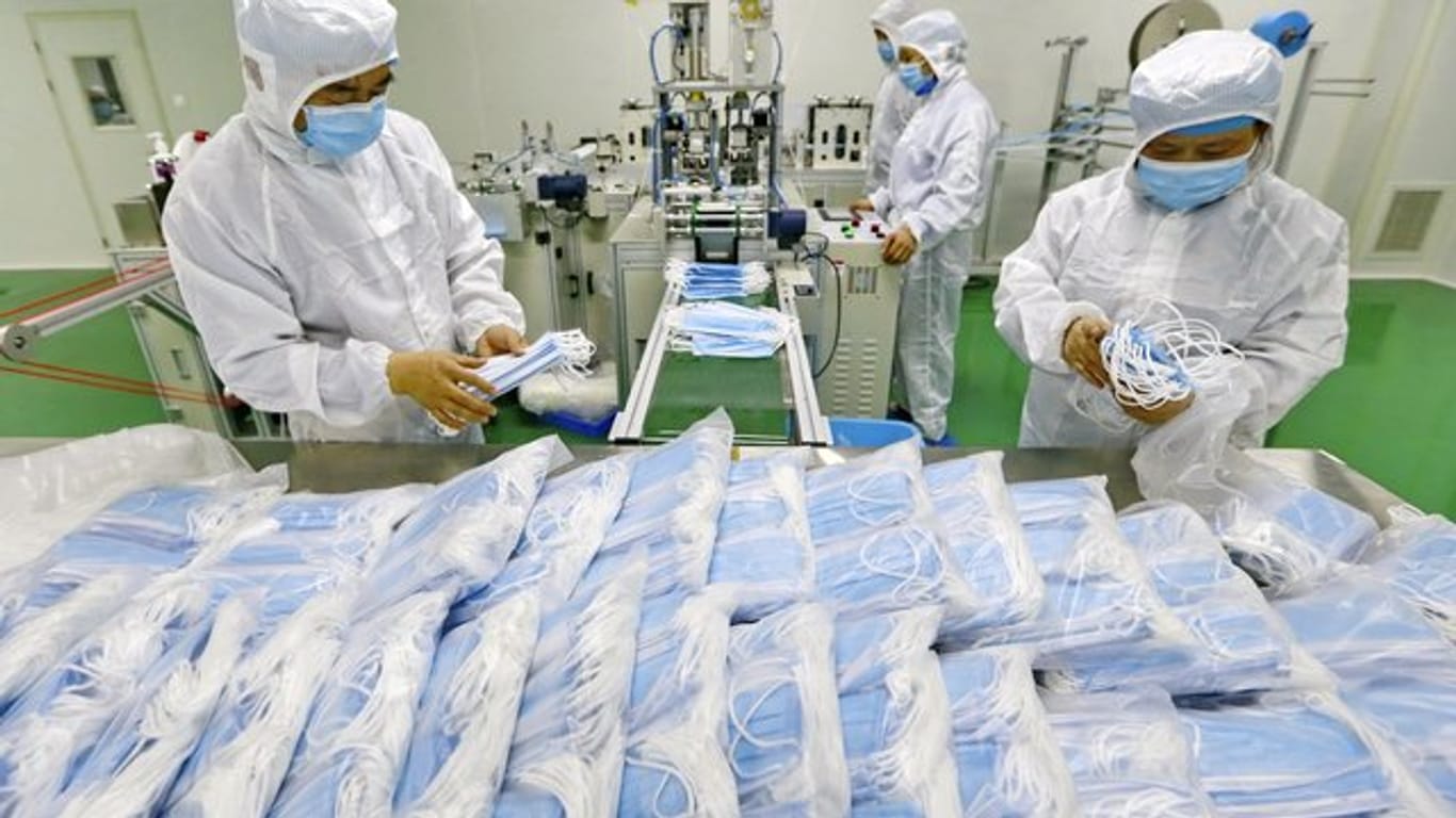 Arbeiter verpacken Schutzmasken: Die Zahl neuer Infektionen ist in China erneut gestiegen.
