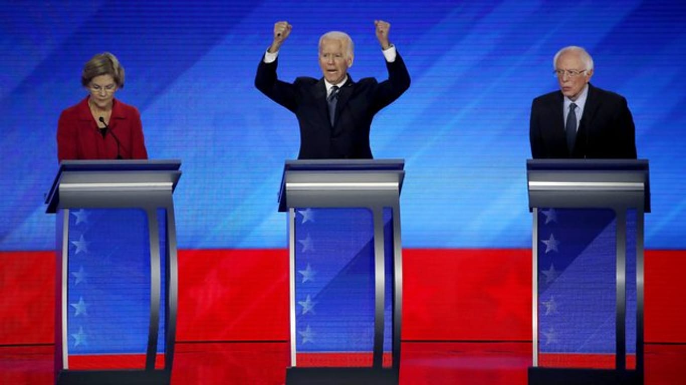 Gestikulierend: Elizabeth Warren (l) und Bernie Sanders (r) hören Joe Biden während der Debatte zu.