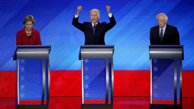 Gestikulierend: Elizabeth Warren (l) und Bernie Sanders (r) hören Joe Biden während der Debatte zu. Gestikulierend: Elizabeth Warren (l) und Bernie Sanders (r) hören Joe Biden während der Debatte zu.