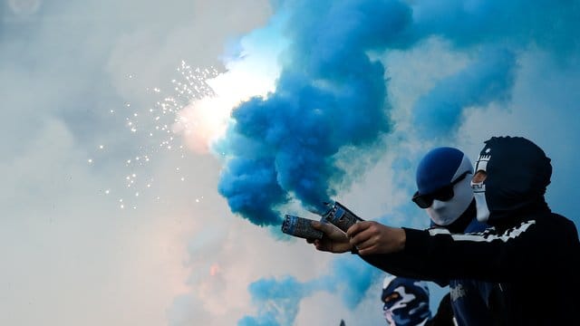 Fans des Hamburger SV brennen im Spiel Feuerwerk ab.