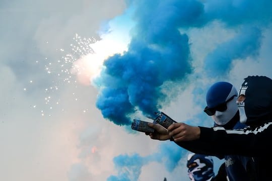 Fans des Hamburger SV brennen im Spiel Feuerwerk ab.