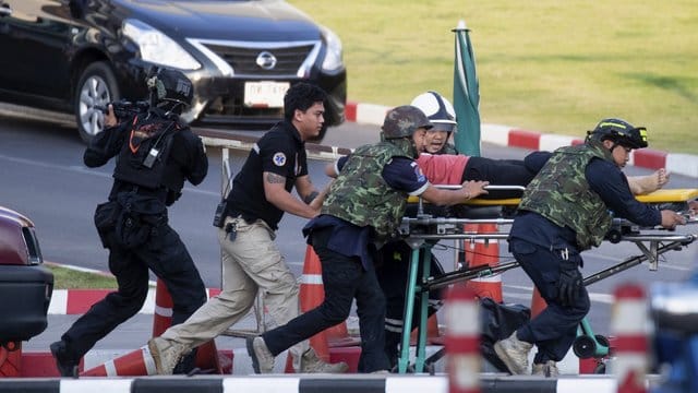 Rettungskräfte bringen einen verletzten Menschen in Sicherheit. Rettungskräfte bringen einen verletzten Menschen in Sicherheit.