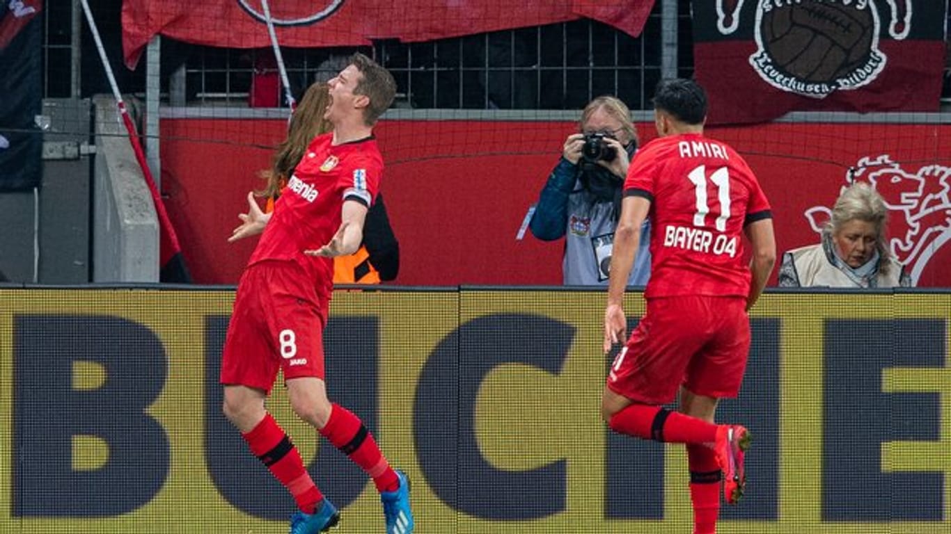 Leverkusens Torschütze Lars Bender (l-r) bejubelt sein Tor zum 4:3 mit Leverkusens Nadiem Amiri.