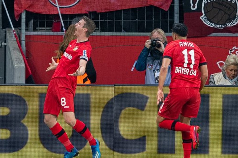 Leverkusens Torschütze Lars Bender (l-r) bejubelt sein Tor zum 4:3 mit Leverkusens Nadiem Amiri.