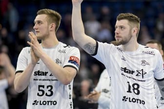 Kiels Nikola Bilyk (l) und Niclas Ekberg feiern den Sieg gegen den HC Erlangen.