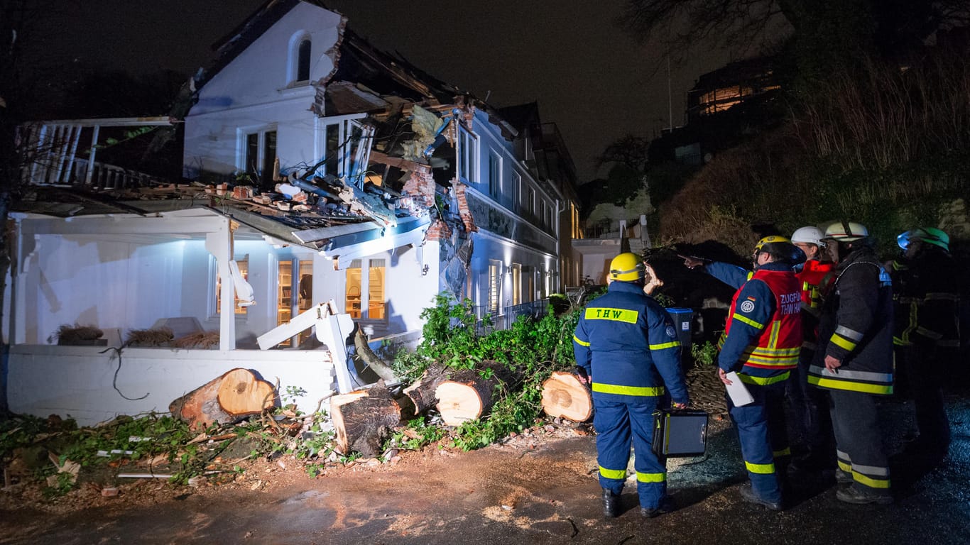 Folgen des Sturmtiefs "Sabine" in Hamburg: Feuerwehrleute stehen an dem stark beschädigten Wohnhaus in Blankenese.