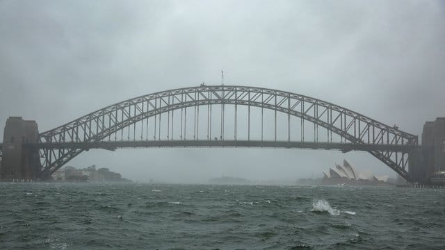 Winde peitschen das Wasser auf: Sydneys Harbour Bridge versinkt im Regenschleier. Winde peitschen das Wasser auf: Sydneys Harbour Bridge versinkt im Regenschleier.