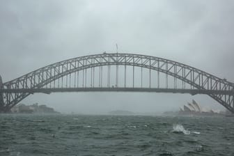 Winde peitschen das Wasser auf: Sydneys Harbour Bridge versinkt im Regenschleier.