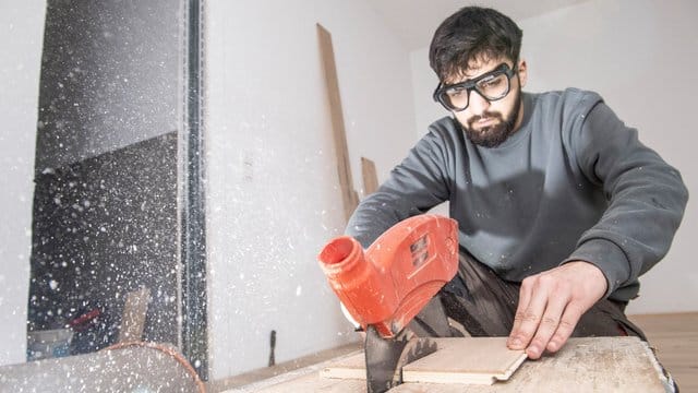 Der Auszubildende Ibrahim Cayli lernt in seiner Ausbildung, worauf es im Umgang mit einer Tischkreissäge ankommt.