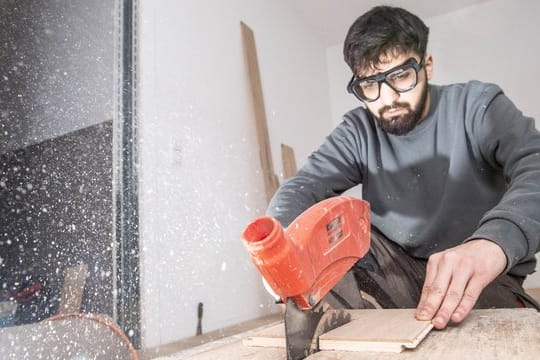 Der Auszubildende Ibrahim Cayli lernt in seiner Ausbildung, worauf es im Umgang mit einer Tischkreissäge ankommt.