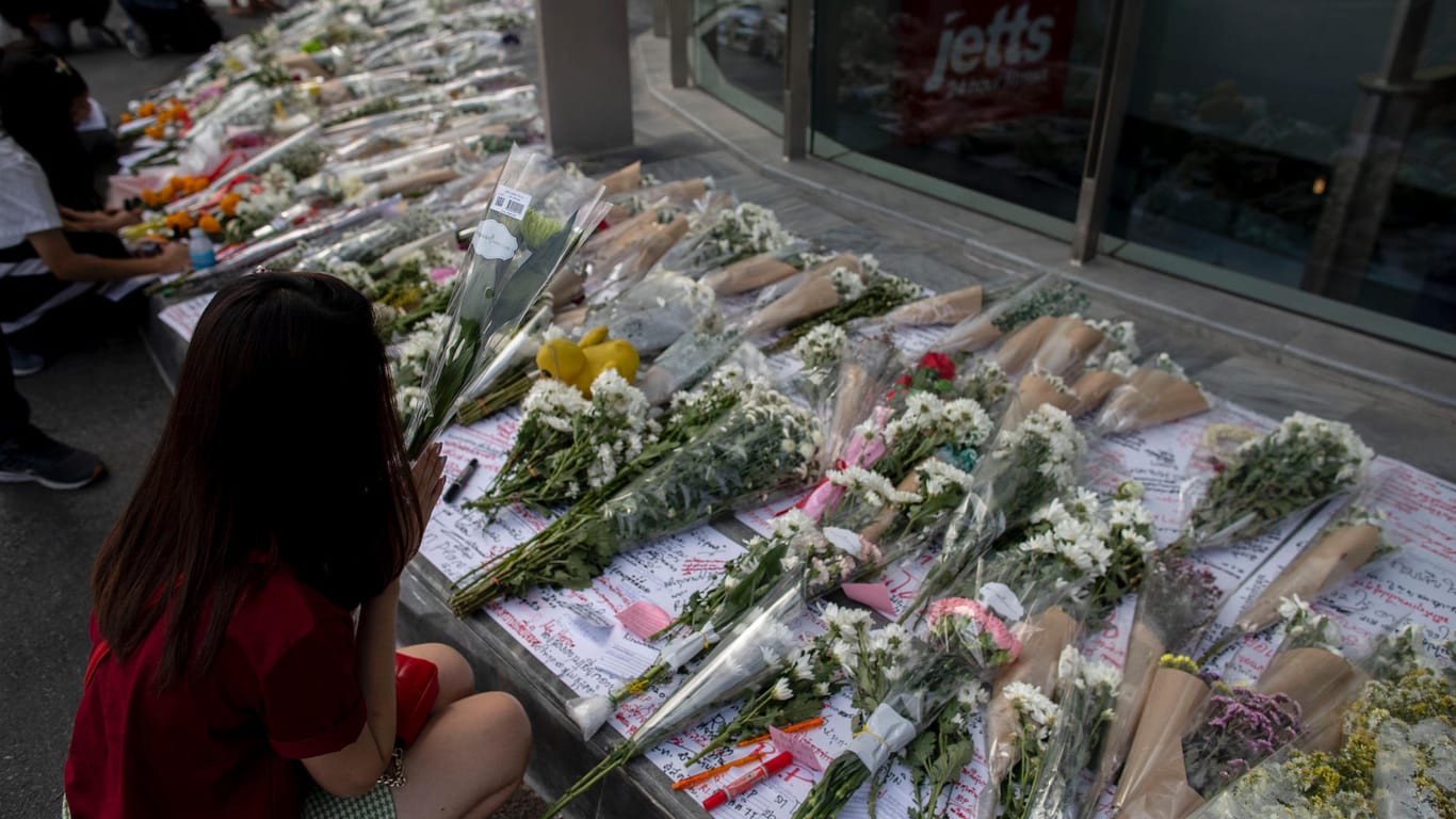 Menschen in Thailand legen Blumen vor dem Einkaufszentrum ab: 30 Menschen kamen bei dem Amoklauf ums Leben.