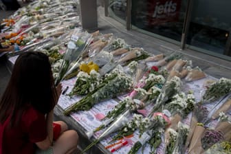 Menschen in Thailand legen Blumen vor dem Einkaufszentrum ab: 30 Menschen kamen bei dem Amoklauf ums Leben.