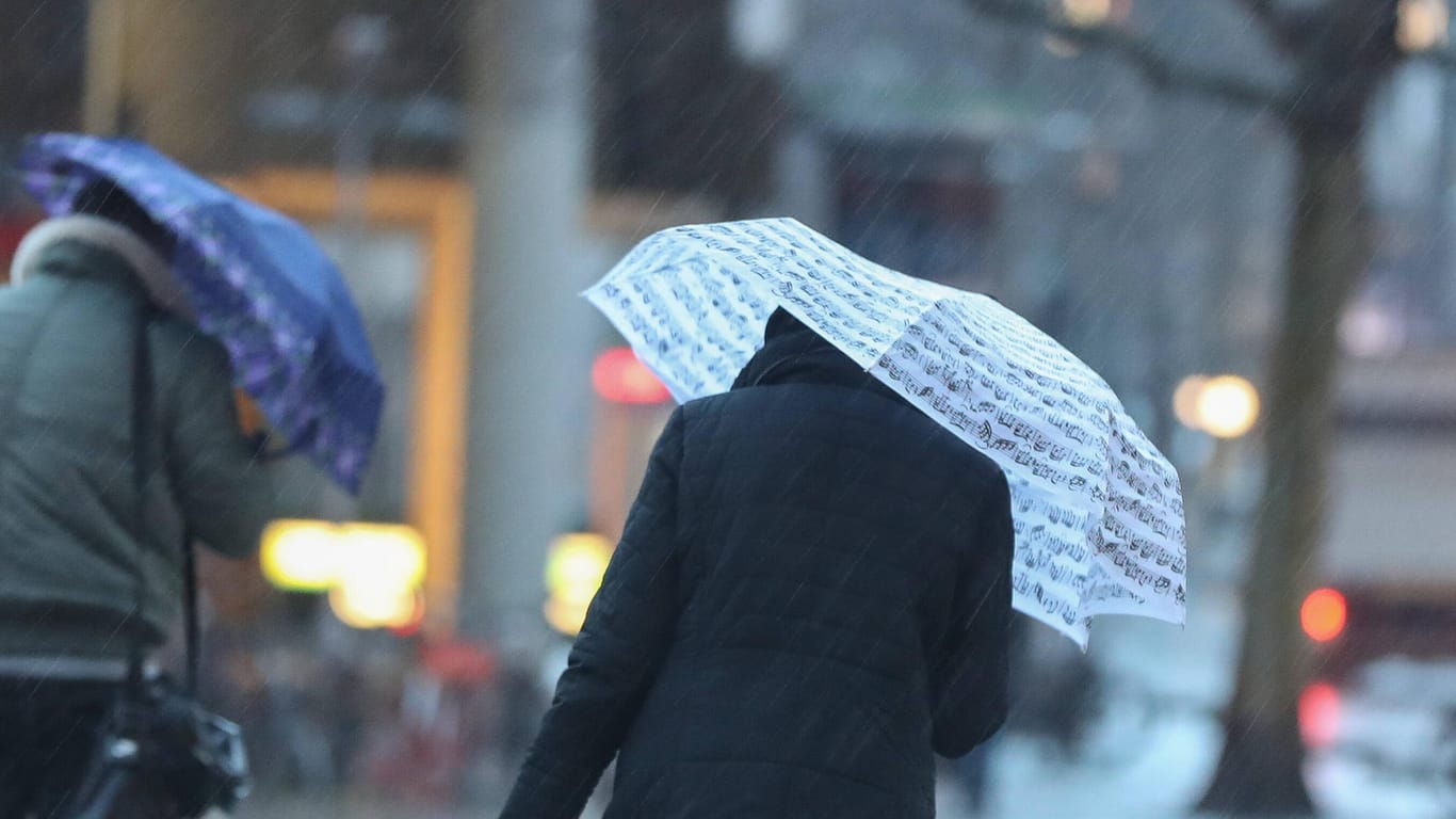 Menschen mit Regenschirm kämpfen gegen den Sturm: In Bielefeld hat "Sabine" weniger Schaden angerichtet als befürchtet (Symbolbild).
