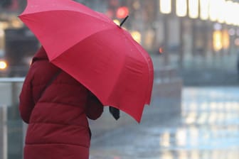 Eine Frau läuft mit einem Regenschirm (Symbolbild): In Mainz hat das Sturmtief "Sabine" keinen größeren Schaden angerichtet.