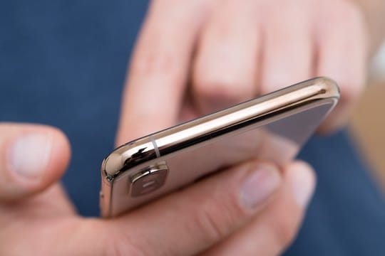 Mensch hält ein Smartphone in der Hand: In Deutschland wurden 2019 insgesamt 2,77 Milliarden Gigabyte im Mobilfunk verbraucht.