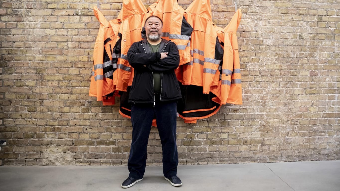 Der chinesische Künstler Ai Weiwei posiert in seinem Atelier: Das Kunstwerk heißt "Safety Jackets Zipped the Other Way"