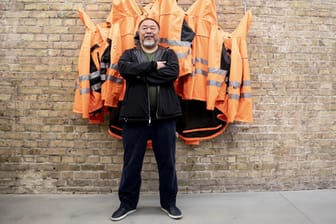 Der chinesische Künstler Ai Weiwei posiert in seinem Atelier: Das Kunstwerk heißt "Safety Jackets Zipped the Other Way"