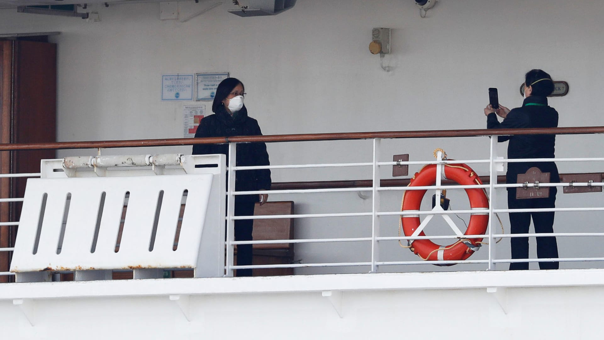 Passengers take photos on a deck of the cruise ship Diamond Princess at Daikoku Pier Cruise Terminal in Yokohama, south of Tokyo, Japan