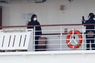 Passengers take photos on a deck of the cruise ship Diamond Princess at Daikoku Pier Cruise Terminal in Yokohama, south of Tokyo, Japan