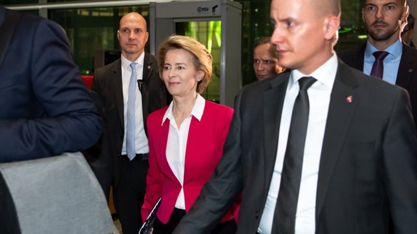 Ursula von der Leyen verlässt von zahlreichen Personenschützern begleitet den Deutschen Bundestag.