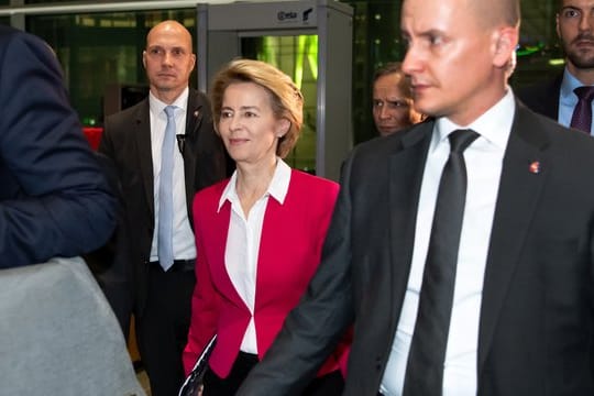 Ursula von der Leyen verlässt von zahlreichen Personenschützern begleitet den Deutschen Bundestag.