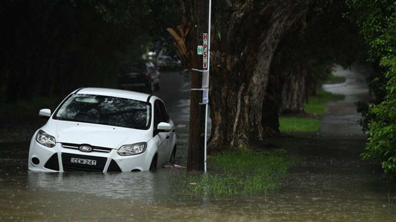 Ein Auto steht in einer überfluteten Straße in Sydney.