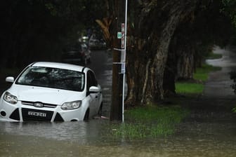 Ein Auto steht in einer überfluteten Straße in Sydney.