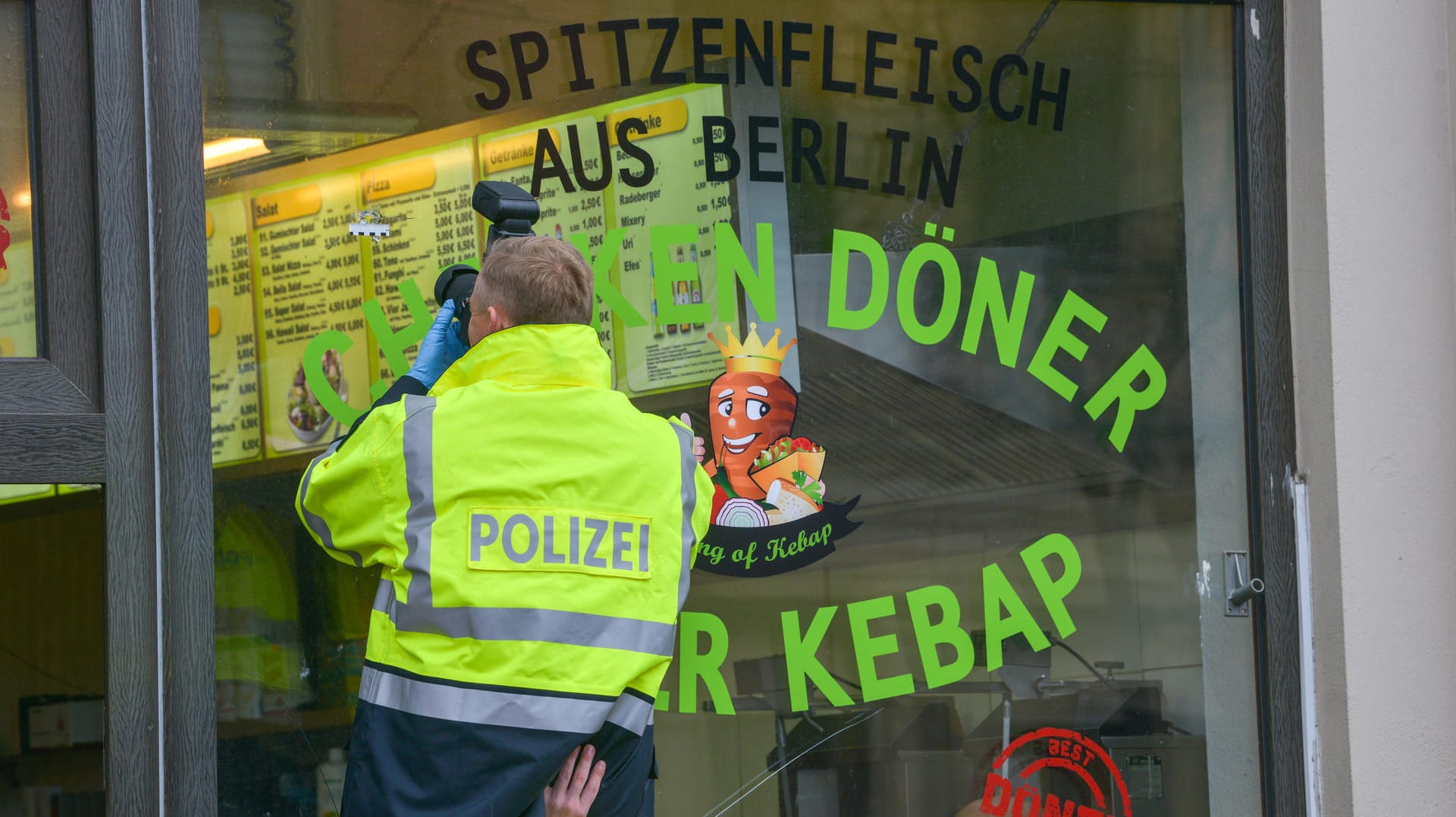 Ein Kriminaltechniker fotografiert das neue Loch: Beim Döner-Imbiss ist nach dem Terroranschlag in Halle der Umsatz eingebrochen. Ein Kriminaltechniker fotografiert das neue Loch: Beim Döner-Imbiss ist nach dem Terroranschlag in Halle der Umsatz eingebrochen.