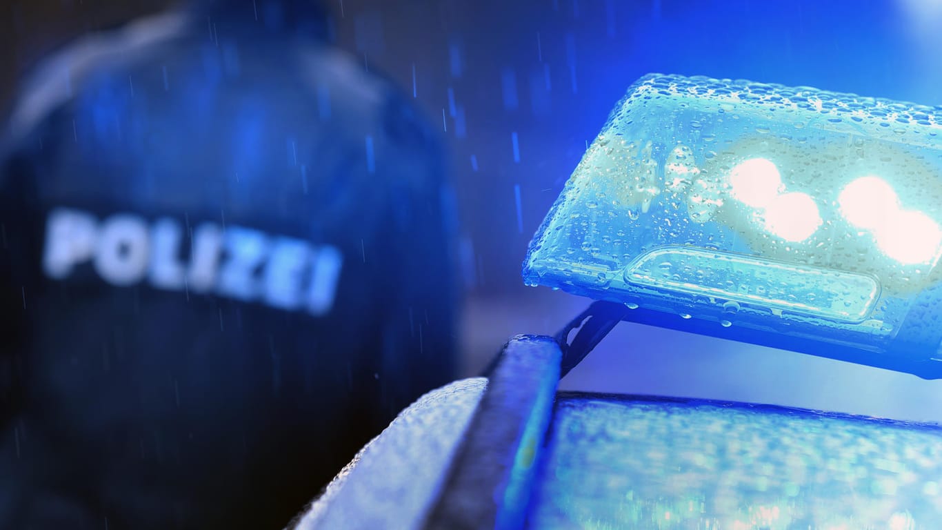 Ein Polizist vor einem Streifenwagen (Symbolbild): In Hessen wurden zwei tote Männer aufgefunden.