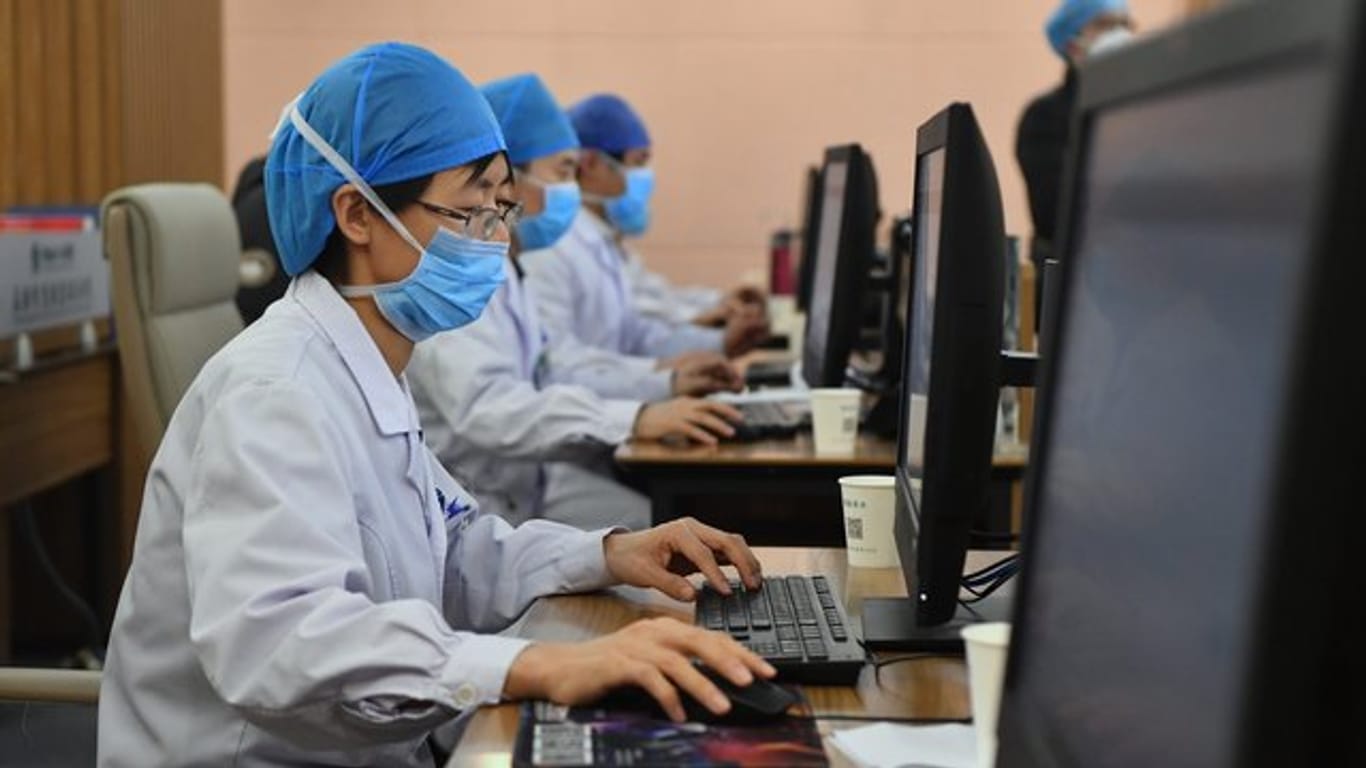 Medizinische Spezialisten mit Mundschutz und Kopfhauben im "Henan Provincial People's Hospital" in der Provinz Henan in Zentralchina an.