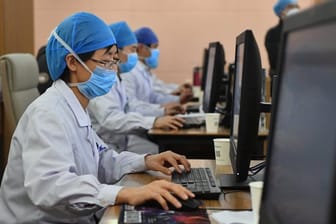 Medizinische Spezialisten mit Mundschutz und Kopfhauben im "Henan Provincial People's Hospital" in der Provinz Henan in Zentralchina an.