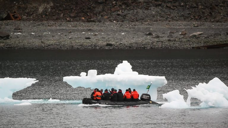 Antarktis-Touristen vor Eisberg-Resten: Die Klimakrise lässt das Antarktis-Eis schmelzen. Wie stark, dafür haben Forscher verschiedene Szenarien entwickelt.