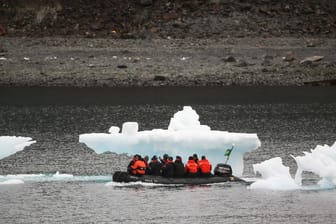 Antarktis-Touristen vor Eisberg-Resten: Die Klimakrise lässt das Antarktis-Eis schmelzen. Wie stark, dafür haben Forscher verschiedene Szenarien entwickelt.