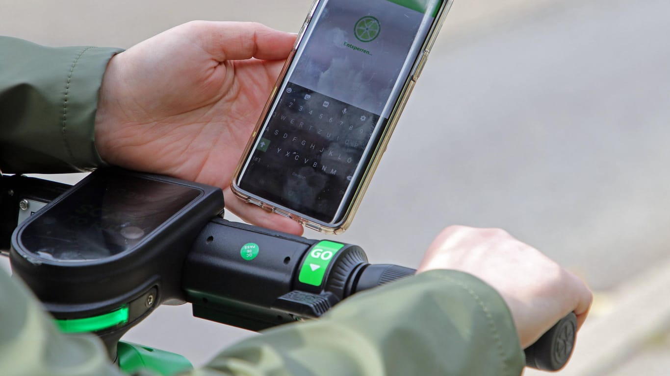 Ein Mann hält sein Smartphone, auf der die "Lime"-App zu sehen ist (Symbolbild): Das Unternehmen will alkoholisierte Fahrer ausbremsen.