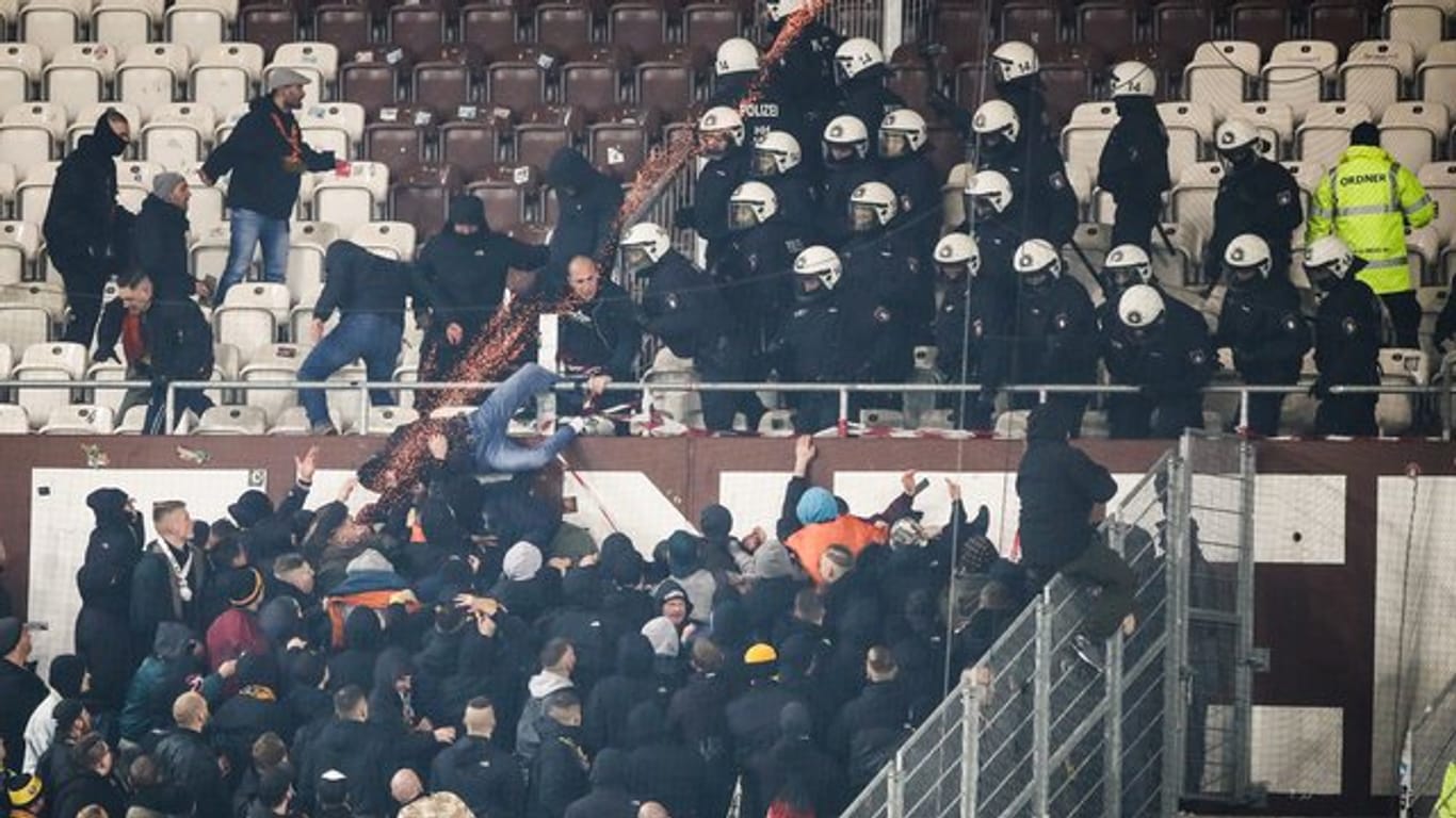 Polizeikräfte drängen randalierende Dresden-Fans zurück in den Gästeblock.